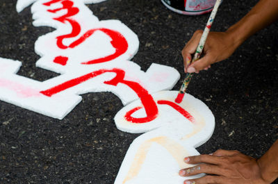 High angle view of hands painting on polystyrene