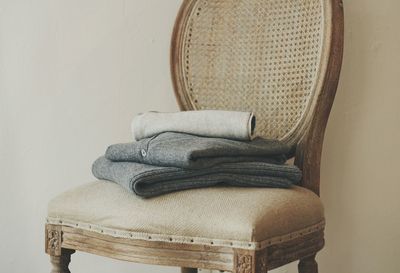 Close-up of clothes on chair against wall at home