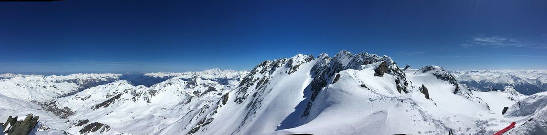 Scenic view of snowcapped mountain against blue sky