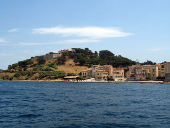 Sea by buildings against sky in city