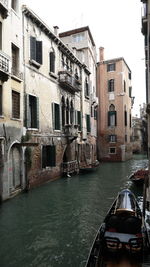 Boats in canal with buildings in background