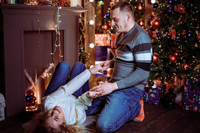 People on christmas tree at home