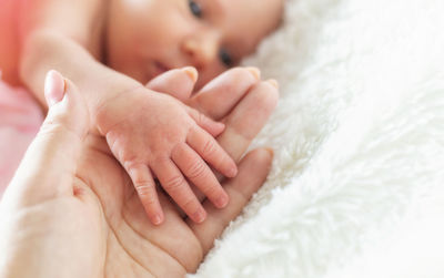 Mother holding hand of baby at home