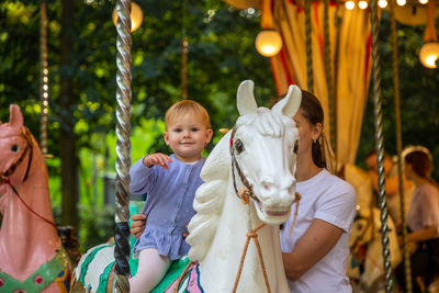 Mother and daughter on carousel