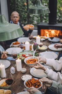 Senior woman holding bowl of carrots during dinner party