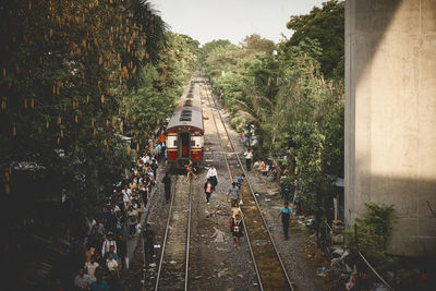 People on street amidst trees against sky