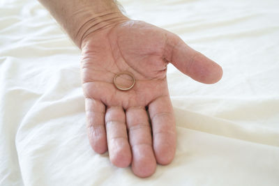 Close-up of human hand on bed