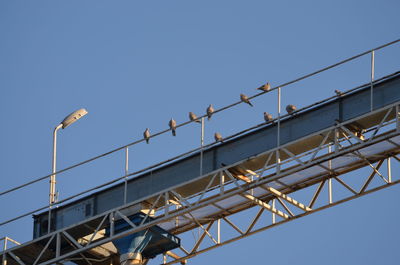 Low angle view of bridge against clear blue sky