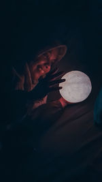 Young woman in hat sitting in darkroom