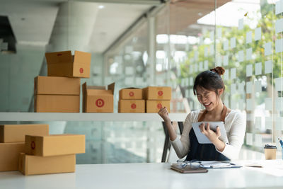 Side view of young woman using mobile phone in office