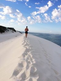 Full length and rear view of man standing on beach