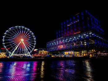 Low angle view of illuminated ferris wheel at night