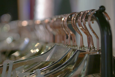 Close-up of coathangers hanging on rack in store