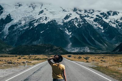 Woman walking against snowcapped mountains