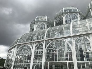 Low angle view of buildings against cloudy sky