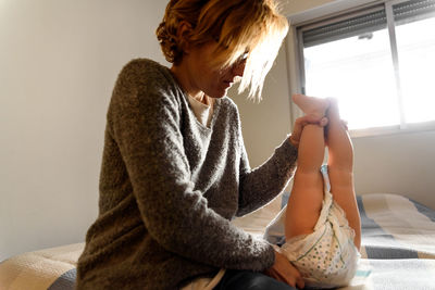 Midsection of woman sitting at home