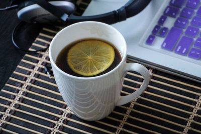 High angle view of herbal tea by laptop and headphones on table