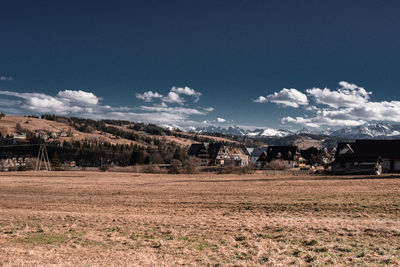 Houses on field against sky