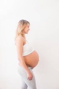 Side view of woman standing against white background