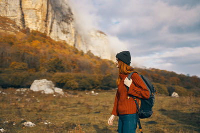 Rear view of man standing on mountain against sky