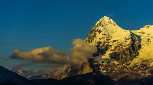 Scenic view of snowcapped mountains against blue sky