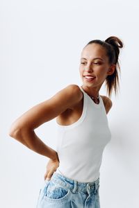 Portrait of young woman standing against white background