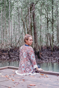 Portrait of young woman standing in forest