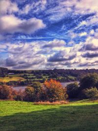 Scenic view of field against cloudy sky