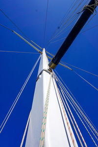 Low angle view of sailboat against clear blue sky