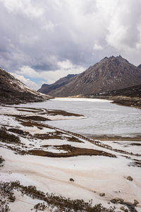 Frozen lake with mountain valley background in winter at day from flat angle