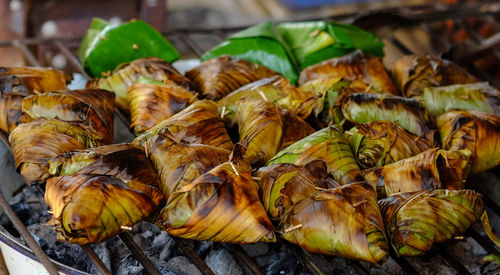 Toast sticky rice, traditional asian or thai street food wrapped in banana leaf on grill.