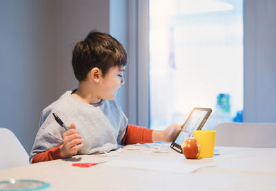 Boy sitting on table at home