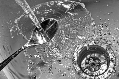 Water pouring on spoon in sink