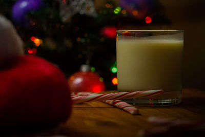 Close-up of drink by candy canes in glass on table