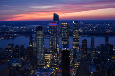 Illuminated cityscape against sky during sunset