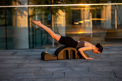 Side view of woman sitting on floor