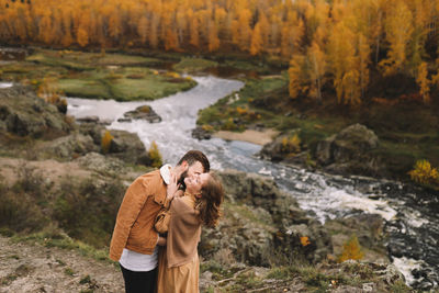 Happy people in love are travel hike in nature in the autumn forest. romantic trip to countryside