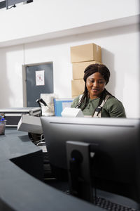 Portrait of young woman using laptop at office