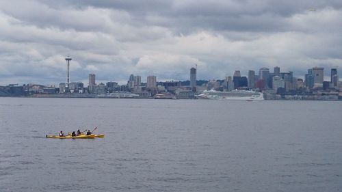 Boats in river with city in background