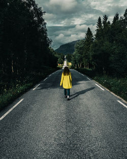 Rear view of woman walking on road