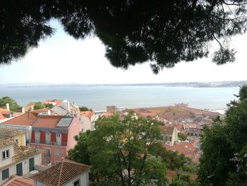 High angle view of townscape by sea against sky