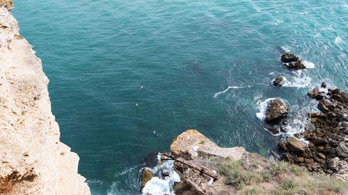 High angle view of rocks on sea shore