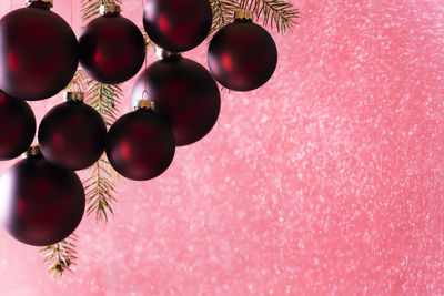 Close-up of red christmas ornaments hanging against wall