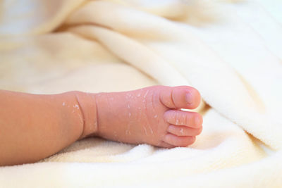 Close-up of baby hand on bed