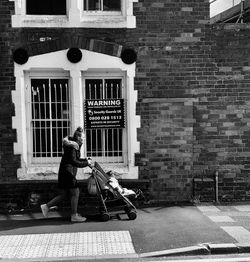 Full length of man walking on street against building