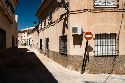 Road sign on street amidst buildings in city