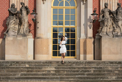 Statue of woman against building