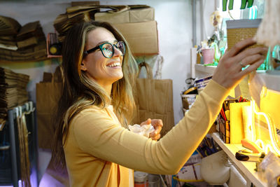 Portrait of happy young woman holding camera