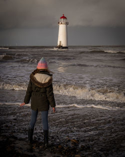 Rear view of woman standing at beach