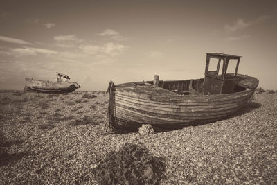 Boat moored on beach against sky